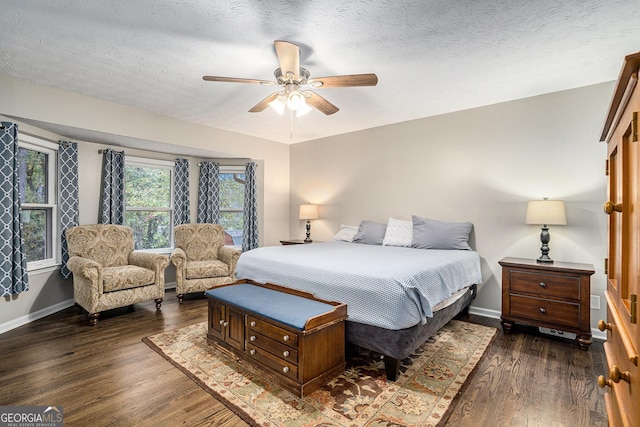 bedroom with ceiling fan, dark hardwood / wood-style flooring, and a textured ceiling