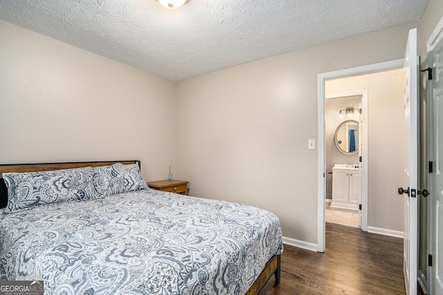 bedroom featuring dark hardwood / wood-style flooring, a textured ceiling, and sink