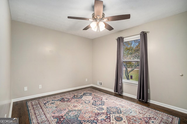 empty room featuring a textured ceiling, dark hardwood / wood-style floors, and ceiling fan