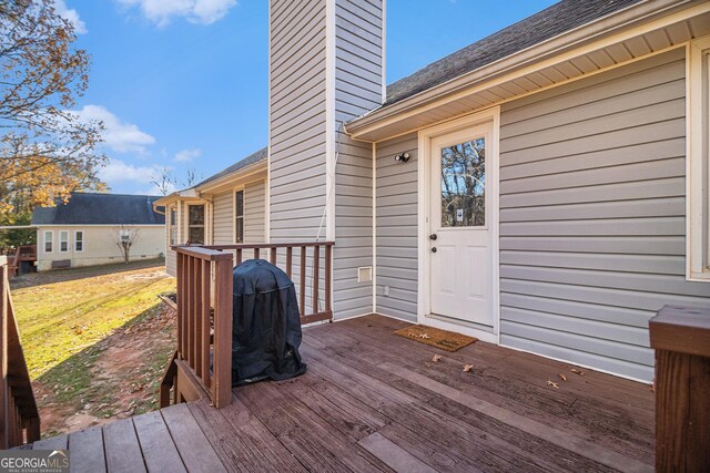 wooden terrace featuring a lawn