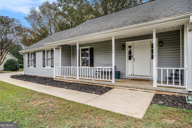 view of exterior entry featuring covered porch