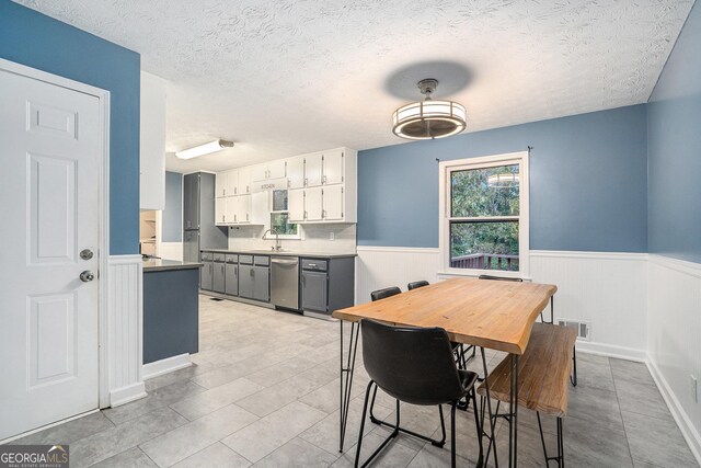 dining space featuring a textured ceiling and sink