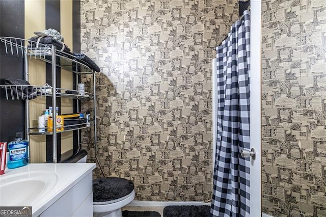 bathroom with toilet, vanity, and curtained shower