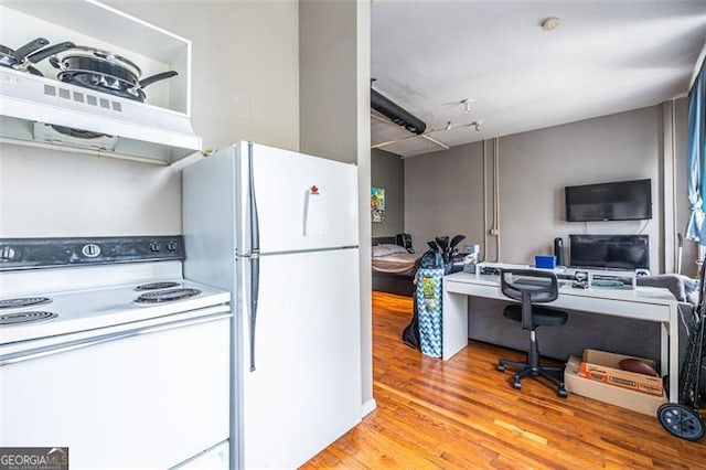 kitchen with light hardwood / wood-style floors, built in desk, white appliances, and ventilation hood