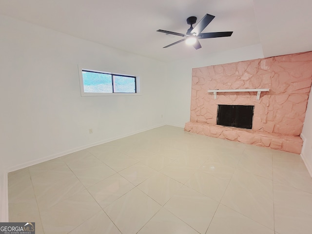 unfurnished living room featuring a fireplace, ceiling fan, and light tile patterned flooring