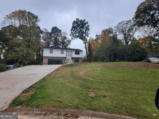 raised ranch with a garage and a front lawn