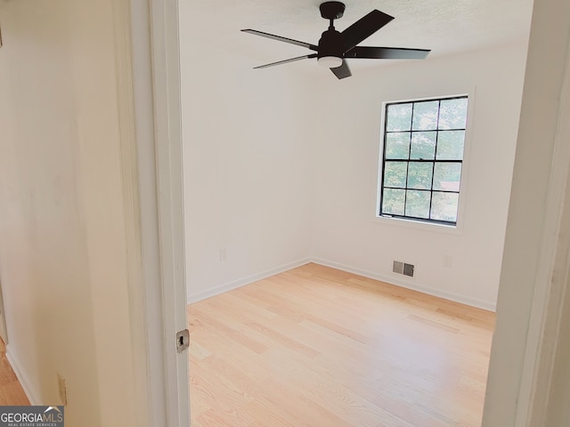 spare room with light wood-type flooring, a textured ceiling, and ceiling fan