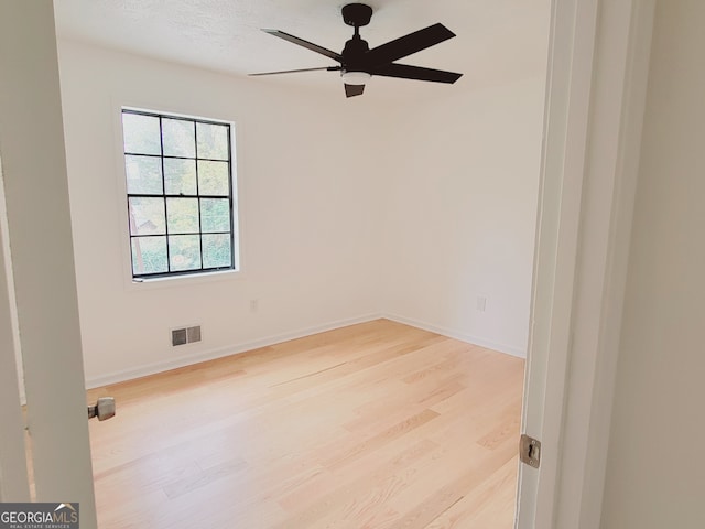 empty room with ceiling fan, a textured ceiling, and light hardwood / wood-style floors