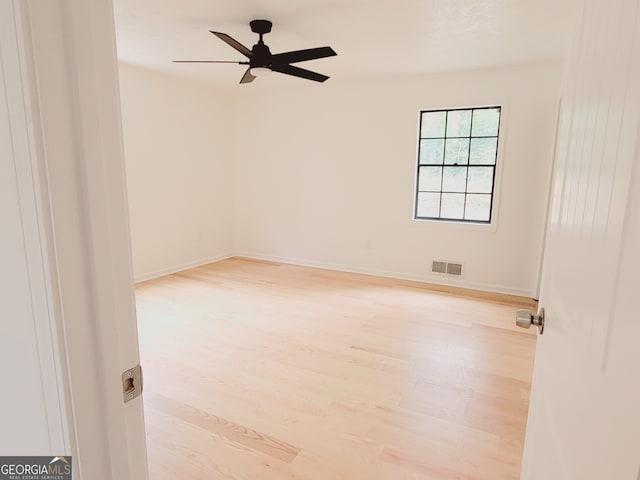 empty room with ceiling fan and light hardwood / wood-style floors