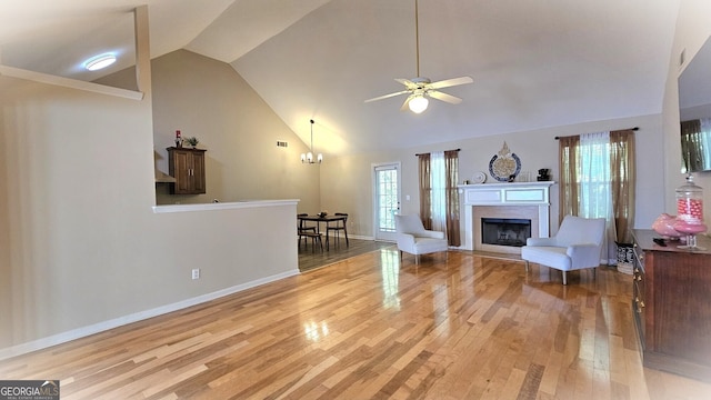 living room featuring ceiling fan with notable chandelier, high vaulted ceiling, and light hardwood / wood-style floors