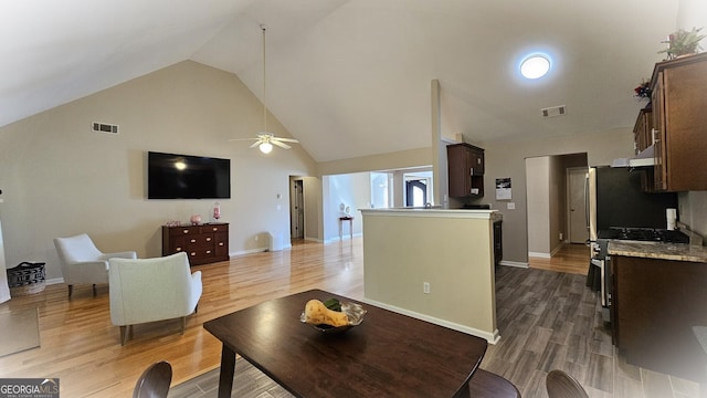 living room featuring hardwood / wood-style floors, high vaulted ceiling, and ceiling fan