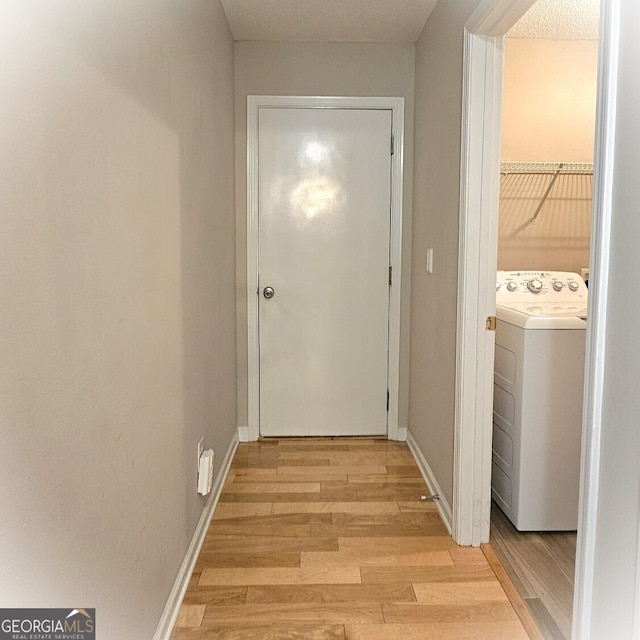 hall with washer / dryer and light hardwood / wood-style floors