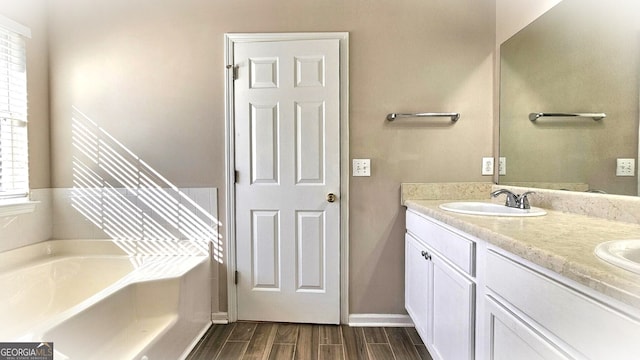 bathroom with vanity, a tub, and hardwood / wood-style flooring