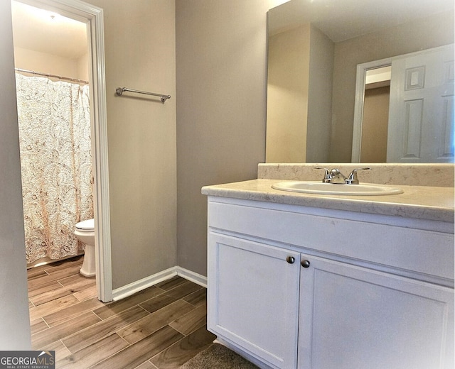 bathroom with vanity, hardwood / wood-style flooring, and toilet