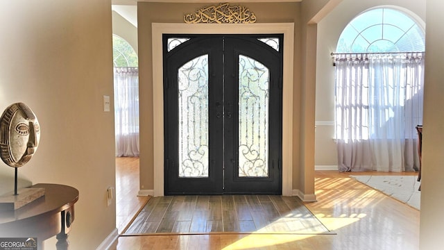 entrance foyer with french doors, light hardwood / wood-style floors, and plenty of natural light