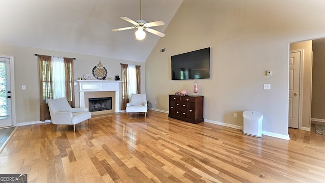 living room featuring ceiling fan, high vaulted ceiling, and light wood-type flooring