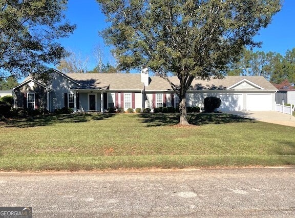 ranch-style house featuring a garage and a front lawn