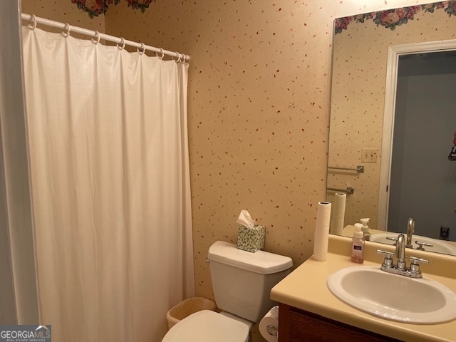 bathroom with walk in shower, vanity, and toilet