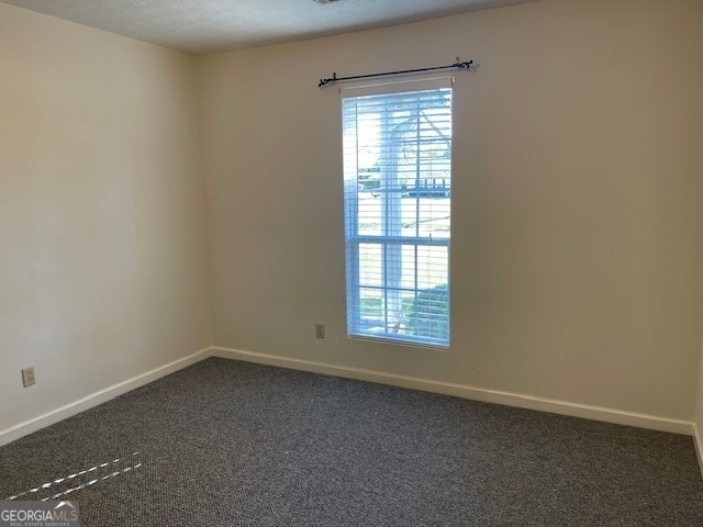 carpeted spare room featuring a textured ceiling