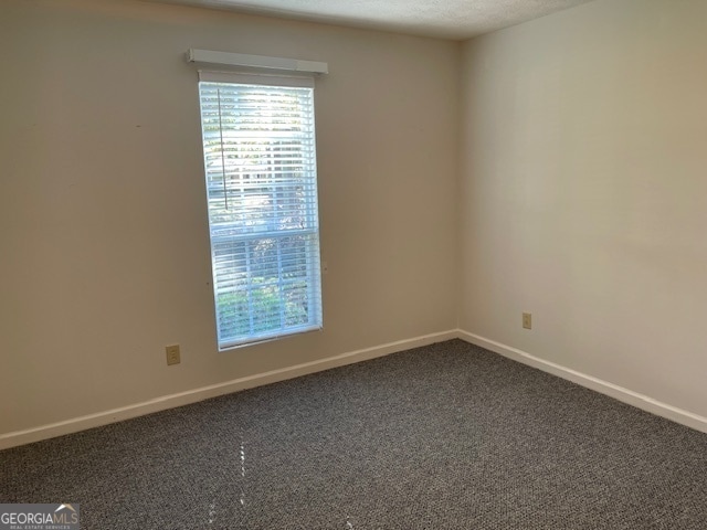 empty room featuring a textured ceiling and carpet