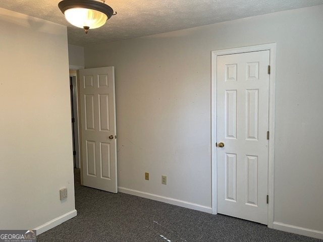 carpeted spare room with a textured ceiling