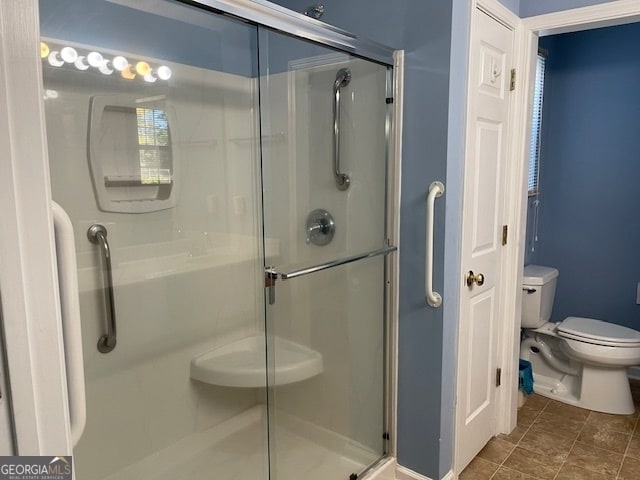 bathroom with toilet and a shower with shower door