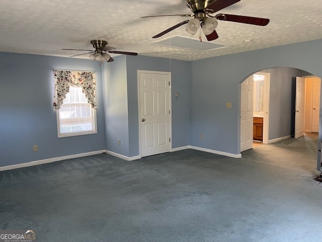 unfurnished room featuring a textured ceiling and dark carpet