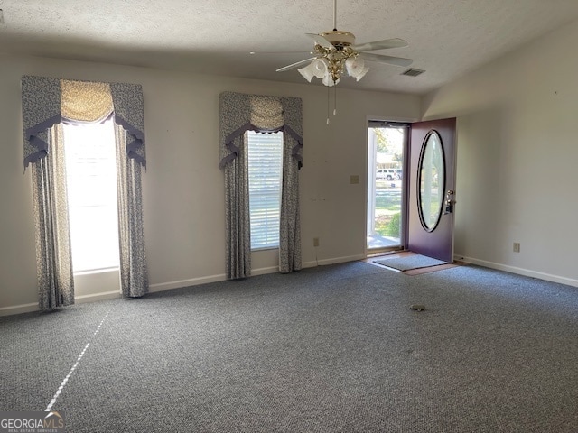 interior space with a textured ceiling and ceiling fan