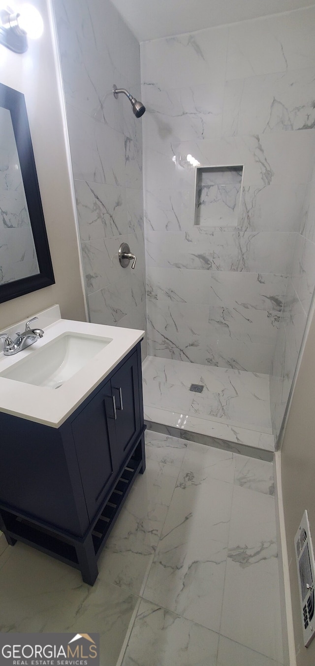 bathroom with vanity and tiled shower