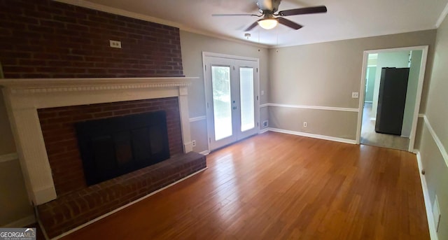 unfurnished living room featuring ornamental molding, a fireplace, wood-type flooring, and ceiling fan