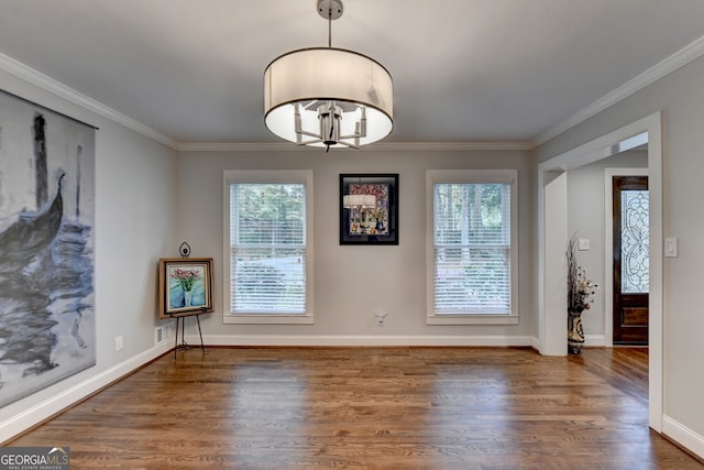 unfurnished dining area featuring dark wood-type flooring and crown molding