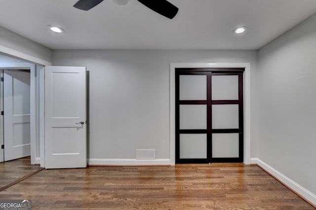 unfurnished room with ceiling fan and wood-type flooring