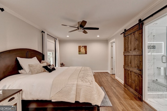 bedroom featuring ornamental molding, a barn door, ensuite bathroom, ceiling fan, and light hardwood / wood-style flooring