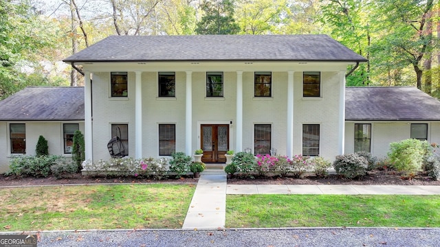 view of front of house with a front lawn and french doors