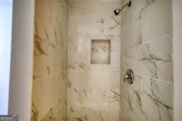 interior details with a tile shower