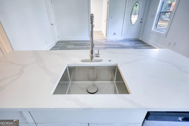 interior details featuring light stone countertops and sink