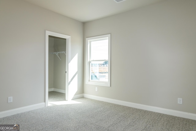 unfurnished bedroom with light colored carpet and a closet