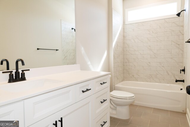 full bathroom featuring vanity, tile patterned floors, toilet, and tiled shower / bath