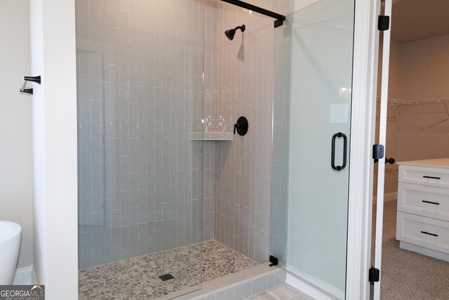 bathroom with a shower with door