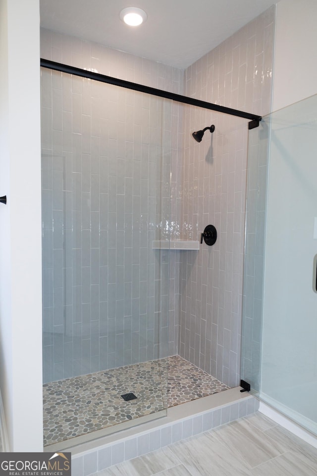 bathroom featuring tile patterned flooring and a tile shower