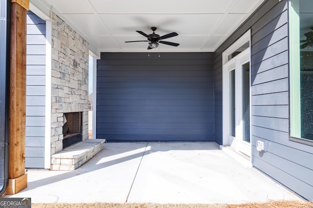 view of patio / terrace featuring ceiling fan and an outdoor stone fireplace