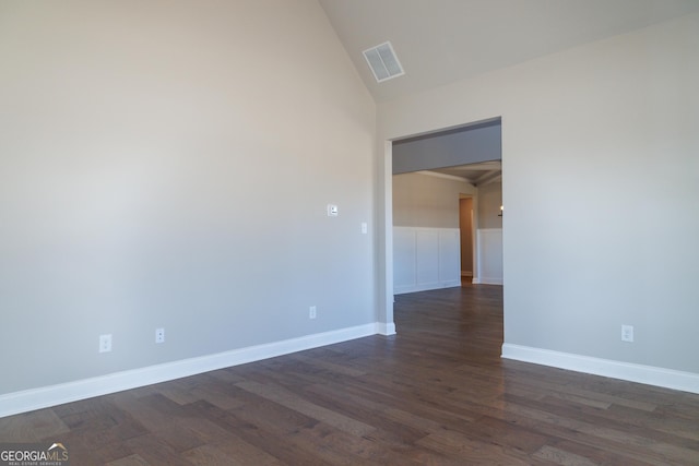 empty room with lofted ceiling and dark wood-type flooring