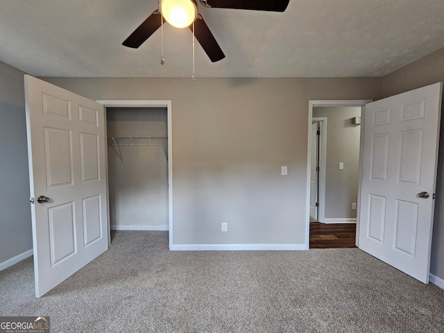 unfurnished bedroom with a textured ceiling, carpet floors, ceiling fan, and a closet