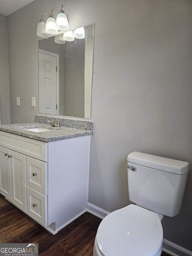 bathroom with toilet, vanity, and hardwood / wood-style flooring