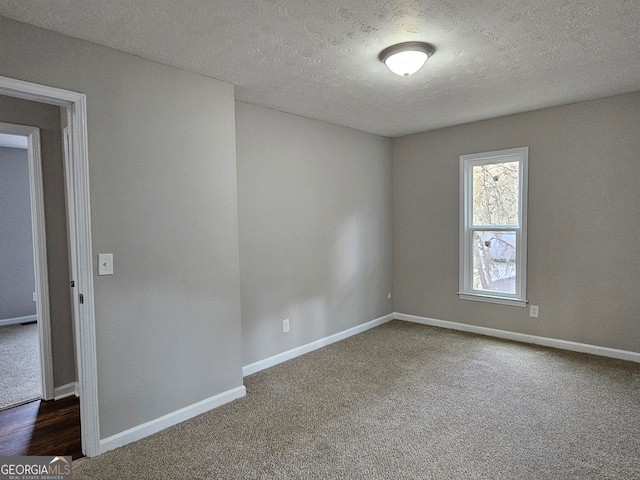 carpeted spare room featuring a textured ceiling