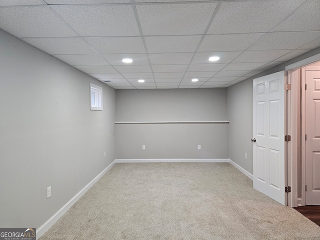 basement with a paneled ceiling and carpet floors