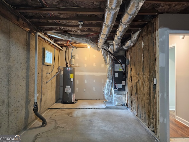 utility room with heating unit and electric water heater