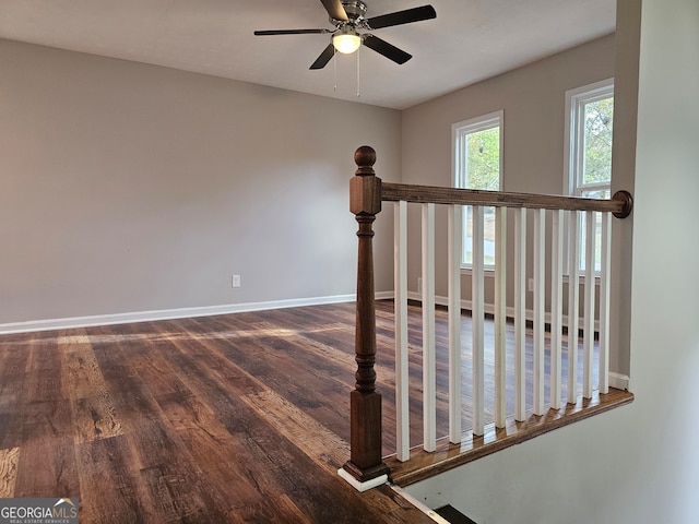 stairway with ceiling fan and wood-type flooring