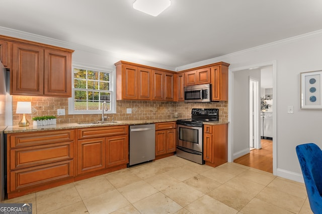 kitchen with light stone countertops, sink, tasteful backsplash, crown molding, and appliances with stainless steel finishes