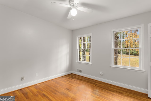 unfurnished room with wood-type flooring, plenty of natural light, and ceiling fan